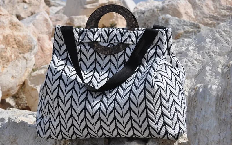 Blue in Green herringbone bag with cork-ring handles on Cretan rocks