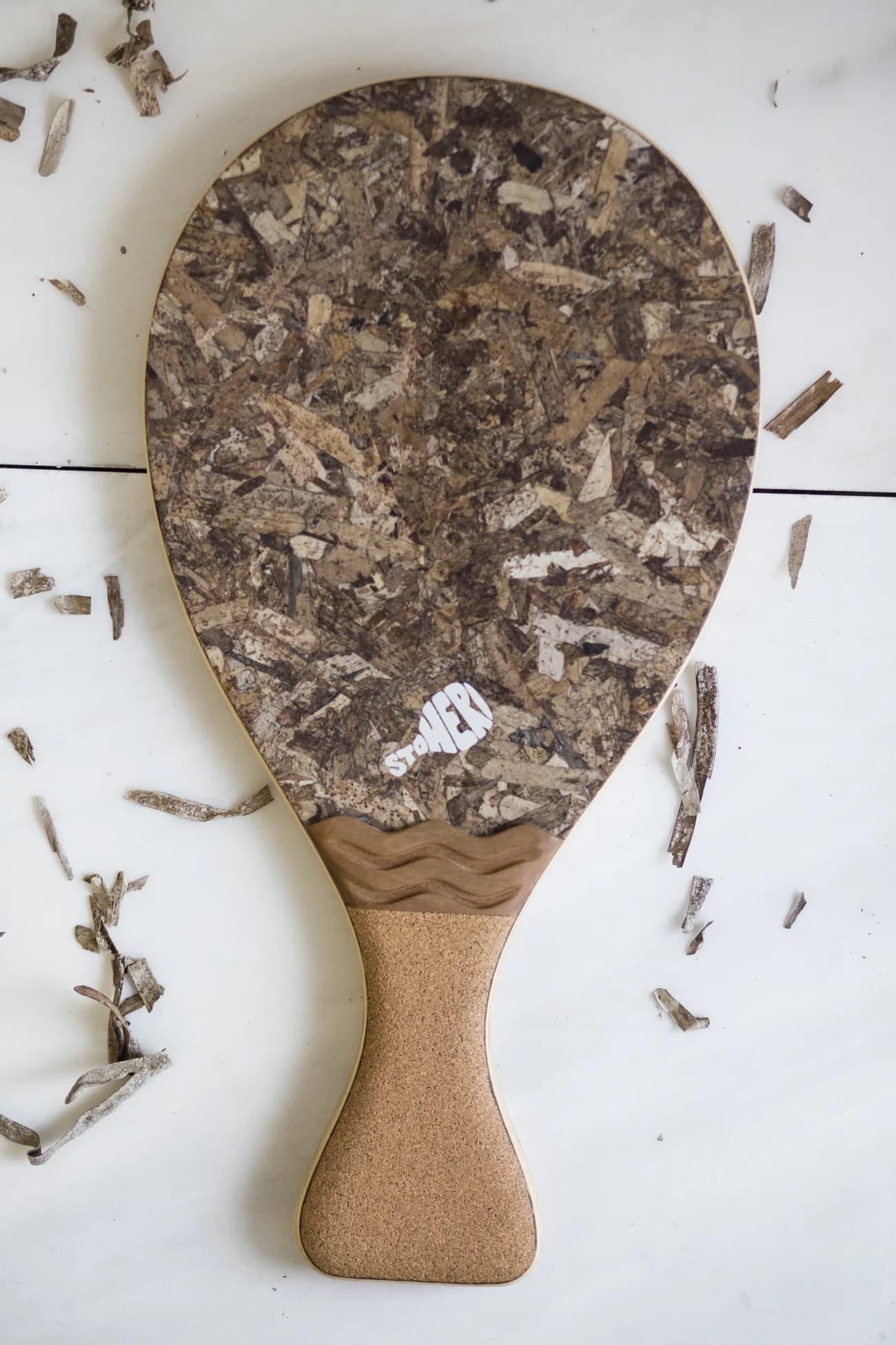 StoHeri racket flat-laid with seagrass sunglasses and a beach towel